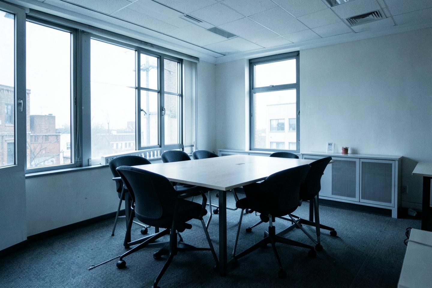 Empty meeting room with a plain table and chairs in natural light